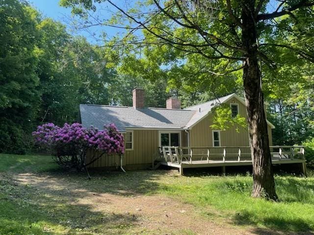 rear view of house featuring a wooden deck