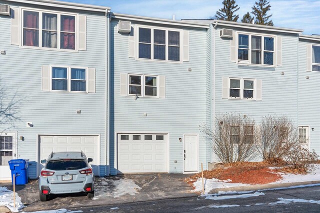 snow covered rear of property with a garage