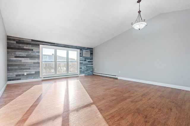 spare room with hardwood / wood-style floors, vaulted ceiling, a wall unit AC, and a baseboard heating unit