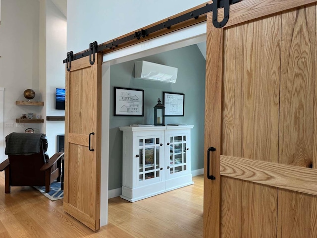 interior space with a barn door and hardwood / wood-style flooring