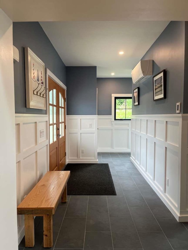 hall with dark tile patterned floors, french doors, and a wall mounted air conditioner