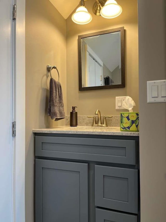 bathroom with lofted ceiling and vanity