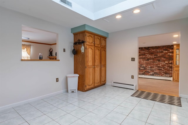 empty room featuring a baseboard radiator, brick wall, and light tile patterned floors