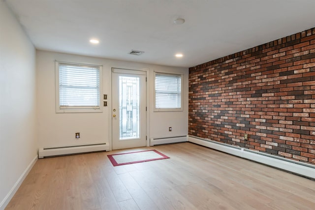 doorway to outside featuring brick wall, a baseboard radiator, and light hardwood / wood-style floors