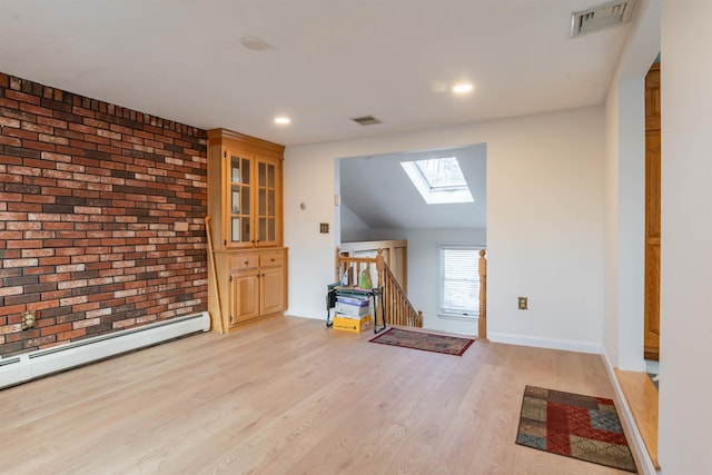 interior space featuring light hardwood / wood-style flooring, a skylight, and a baseboard heating unit