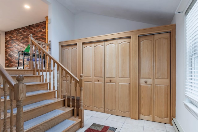 stairway featuring a baseboard radiator, tile patterned flooring, and plenty of natural light