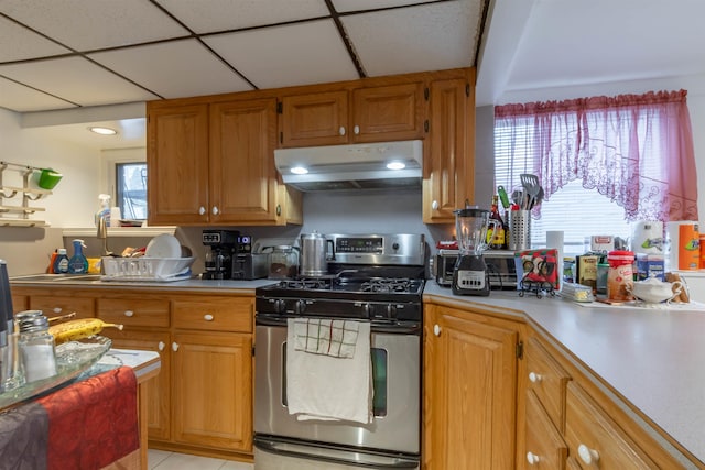 kitchen with stainless steel gas range and light tile patterned floors