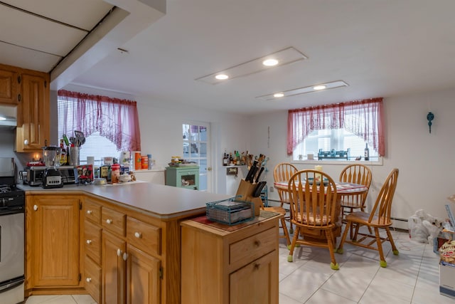 kitchen featuring stainless steel range with gas cooktop, light tile patterned flooring, and kitchen peninsula