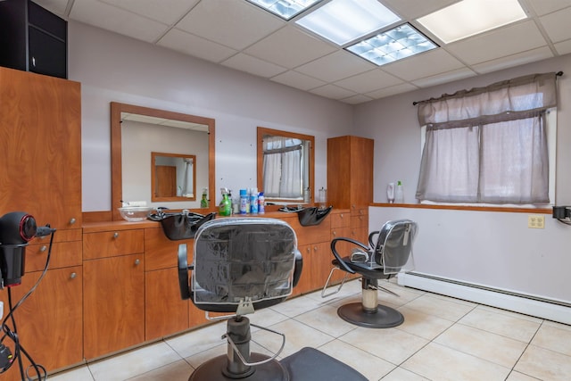 bathroom with baseboard heating, tile patterned flooring, and a drop ceiling