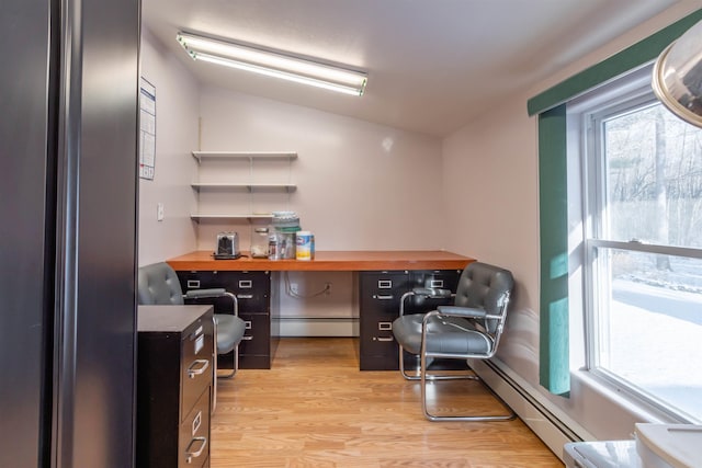 home office with vaulted ceiling, a baseboard radiator, light hardwood / wood-style flooring, and built in desk