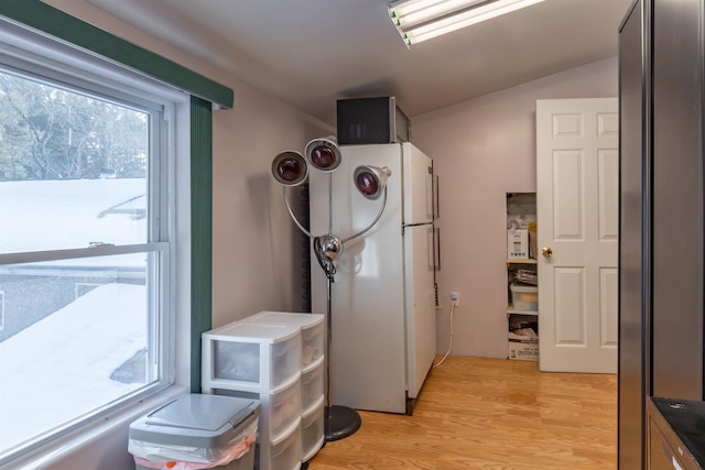 kitchen with stainless steel refrigerator, light hardwood / wood-style floors, and white fridge