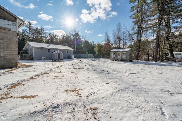 yard covered in snow with a storage unit