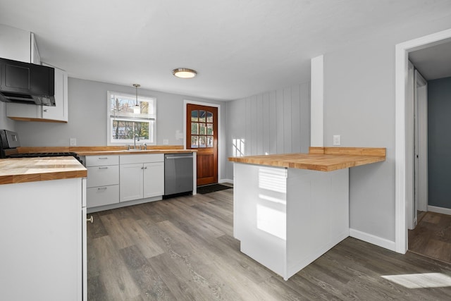 kitchen with kitchen peninsula, white cabinets, butcher block countertops, and hanging light fixtures