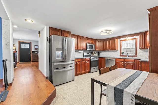 kitchen with stainless steel appliances, decorative backsplash, and sink