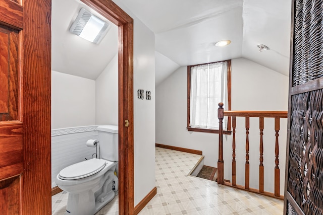 bathroom with lofted ceiling and toilet