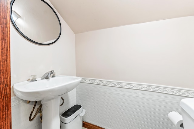 bathroom featuring toilet and tile walls