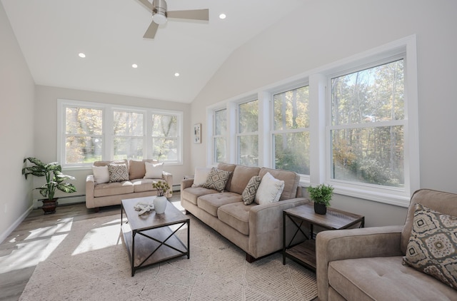 sunroom with lofted ceiling, a baseboard heating unit, and ceiling fan