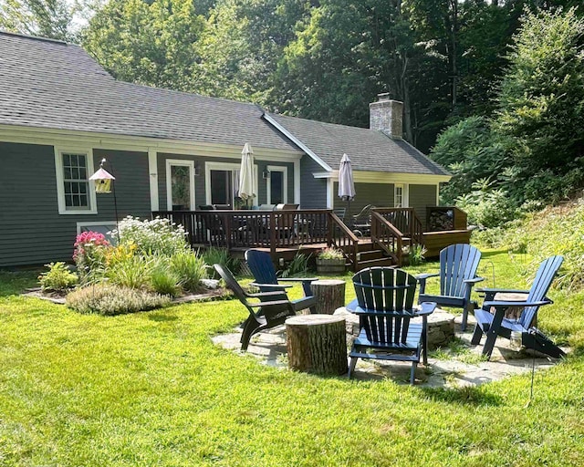 rear view of house featuring a lawn and a wooden deck