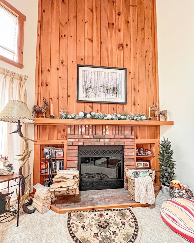 living room featuring wooden walls and a brick fireplace