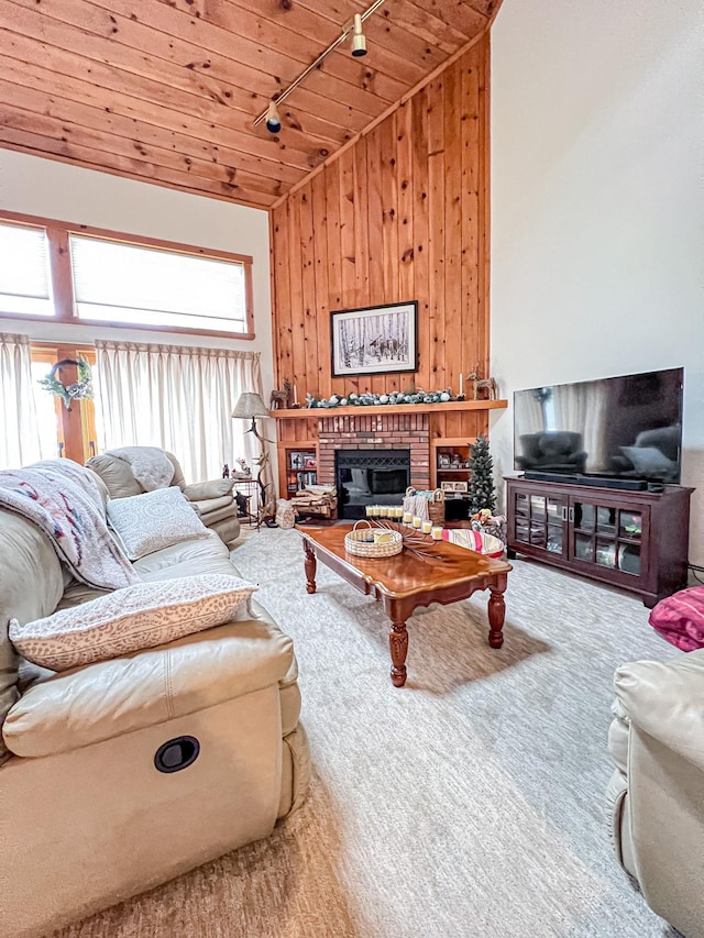 living room featuring a fireplace, high vaulted ceiling, wood walls, and wood ceiling