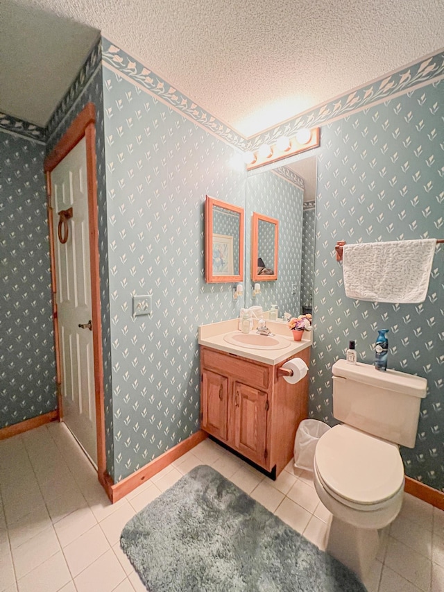 bathroom with toilet, tile patterned flooring, a textured ceiling, and vanity