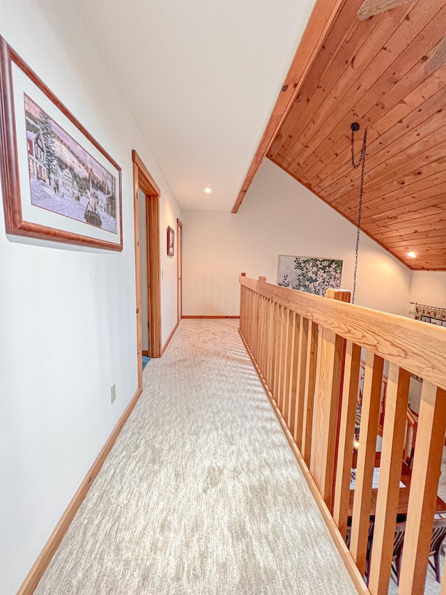 hallway with lofted ceiling, wooden ceiling, and carpet