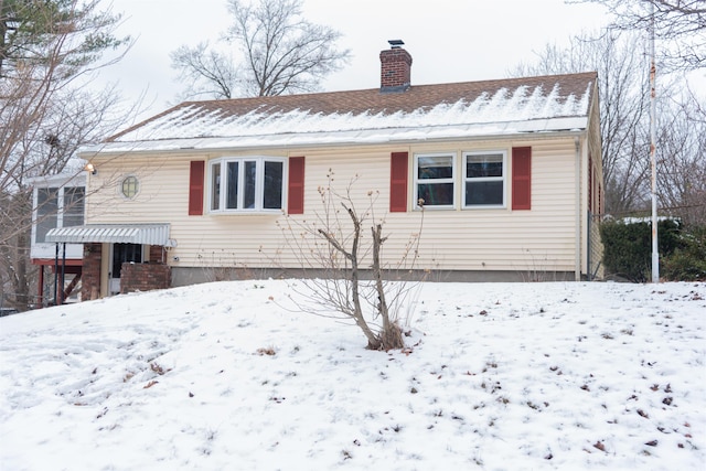 view of snow covered back of property