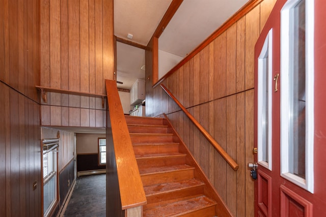 stairs featuring baseboard heating and wooden walls