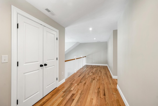 corridor featuring lofted ceiling and light hardwood / wood-style floors