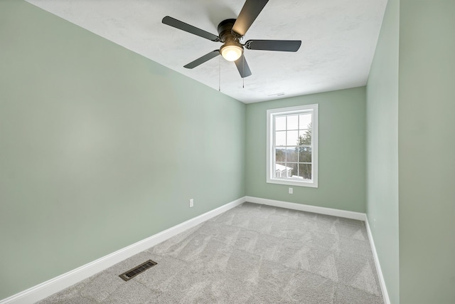 spare room featuring light carpet and ceiling fan