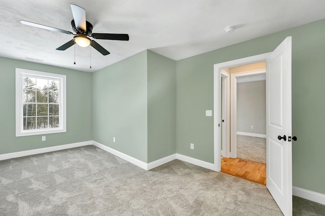 carpeted spare room with ceiling fan