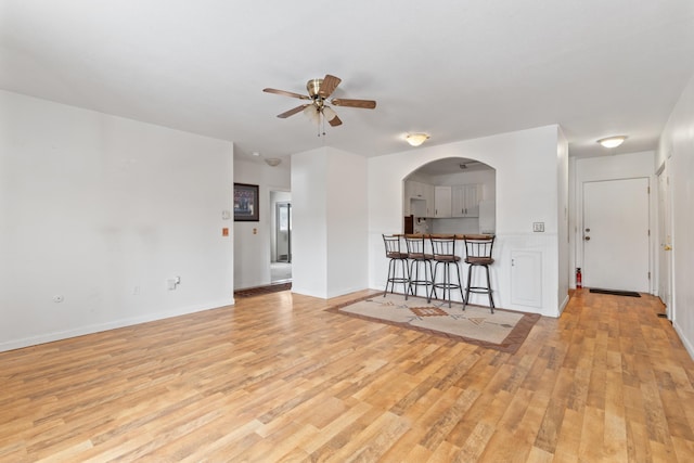 unfurnished living room featuring ceiling fan and light hardwood / wood-style floors