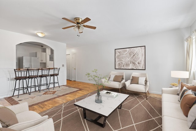 living room with ceiling fan and dark wood-type flooring