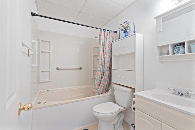 full bathroom featuring toilet, a drop ceiling, shower / tub combo with curtain, and vanity