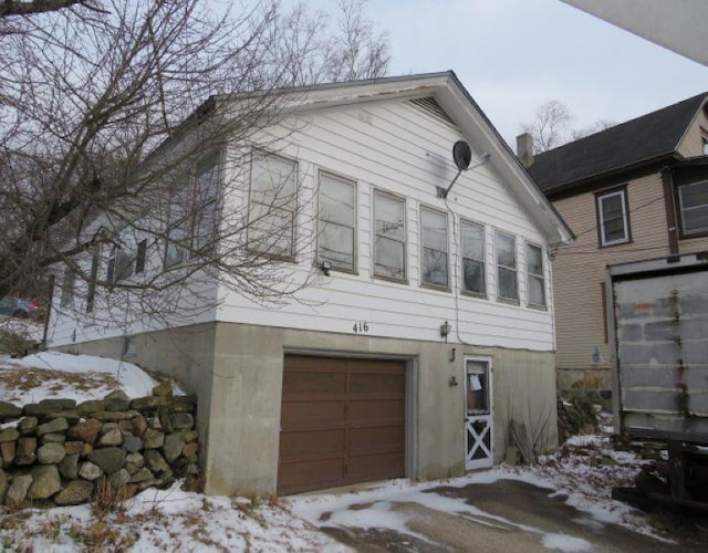 view of snowy exterior with a garage