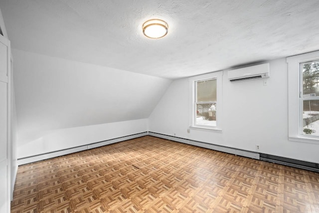 additional living space with lofted ceiling, an AC wall unit, a textured ceiling, and parquet floors