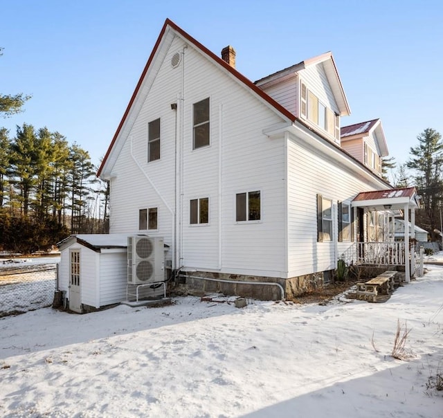 view of snowy exterior with ac unit