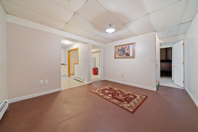 basement featuring a baseboard heating unit and a paneled ceiling