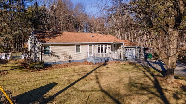 back of house with a yard and a garage