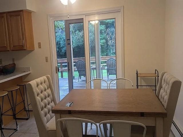 tiled dining room with ceiling fan and a baseboard radiator