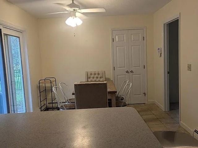 tiled dining space with ceiling fan