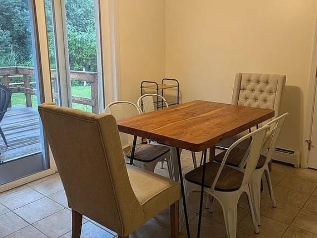 tiled dining space featuring a baseboard heating unit