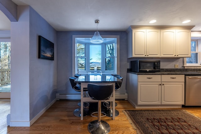 kitchen featuring hardwood / wood-style flooring, white cabinetry, decorative light fixtures, stainless steel dishwasher, and a baseboard heating unit