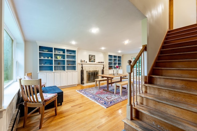 interior space with baseboard heating, light wood-type flooring, and plenty of natural light