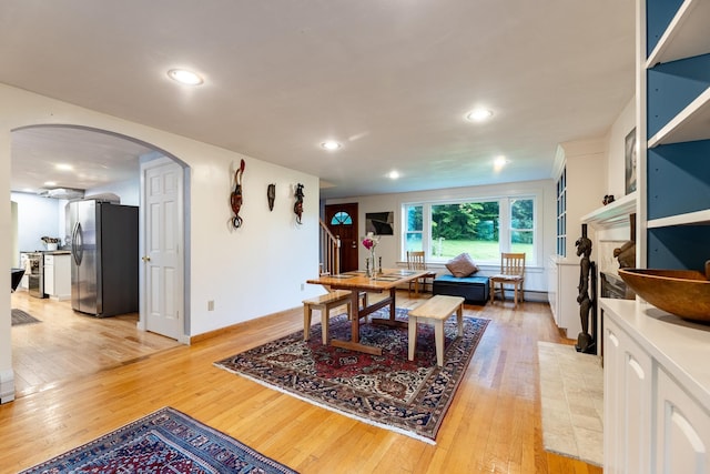 dining room with a fireplace, a baseboard radiator, and light hardwood / wood-style flooring