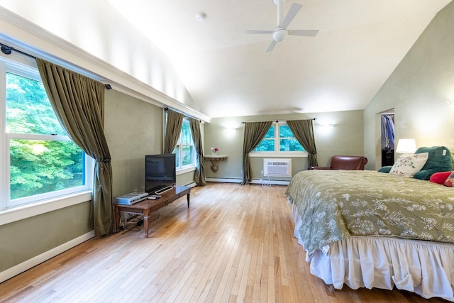 bedroom with ceiling fan, vaulted ceiling, multiple windows, and hardwood / wood-style flooring