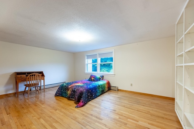 bedroom with a textured ceiling, baseboard heating, and hardwood / wood-style floors