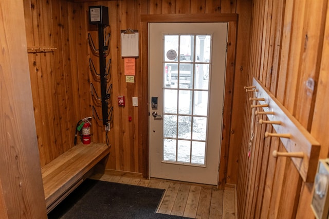 doorway to outside with wooden walls and hardwood / wood-style flooring