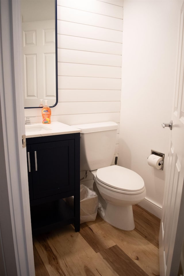 bathroom with toilet, vanity, and hardwood / wood-style floors