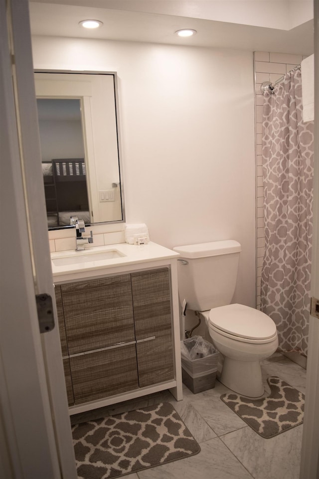 bathroom featuring toilet, vanity, and walk in shower